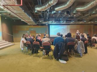 Grand groupe de personnes assises autour d'une table pour effectuer un atelier